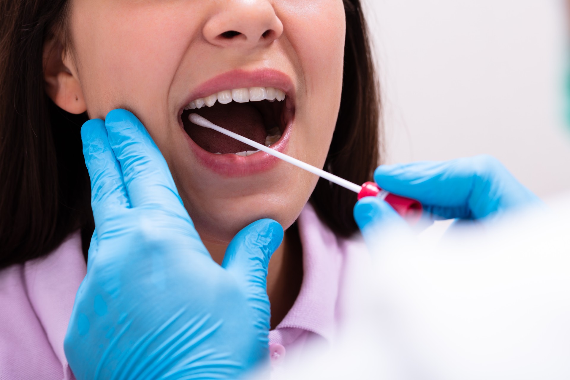 Close-up Of A Doctor Taking Saliva Sample For DNA Test