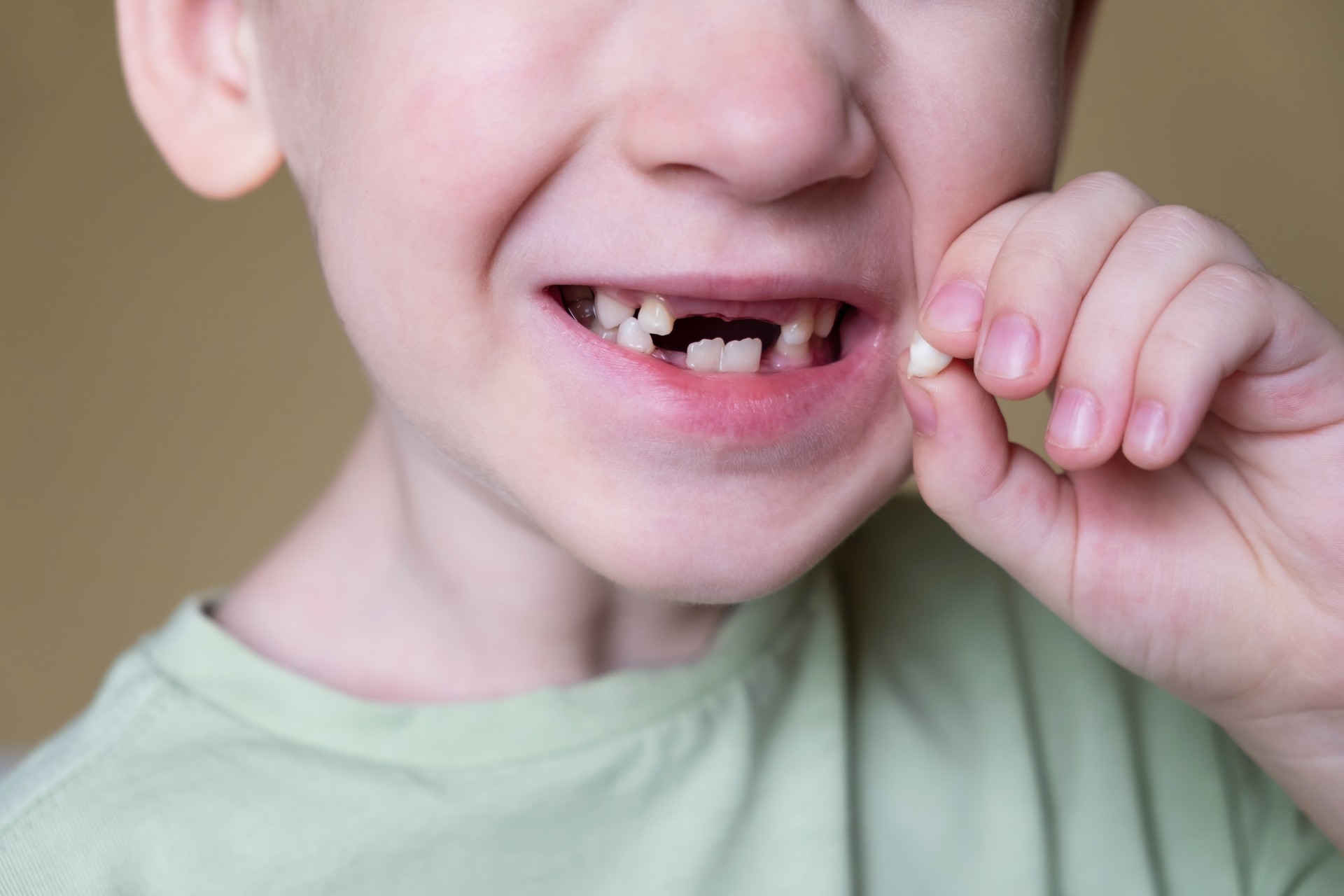 Child shows baby teeth. Caring for childrens teeth